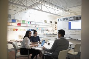 Designers brainstorming, using laptop in creative office
