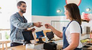 Man paying cashier in cafe