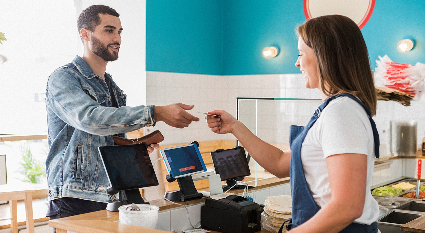 Man paying cashier in cafe