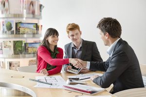 Real estate agent discussing property documents to his clients