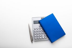 calculator pen and journal on desk