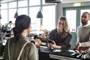 Woman using credit card at restuarant