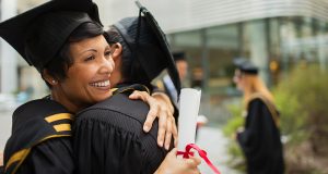 Mature graduate in cap and gown with diploma