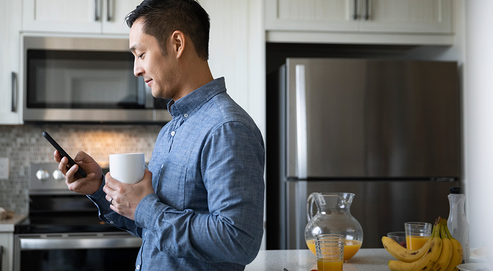 man-mobile-kitchen-med Man using mobile phone in kitchen