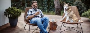relaxed man using smart phone outside with dog