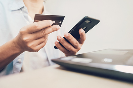 mobile-banking-credit-card-sm personal holding credit card while using mobile device