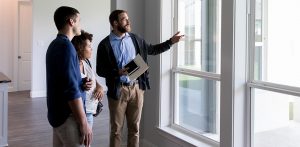 realtor showing home to young couple