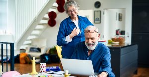 Happy retired couple searching on laptop