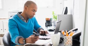 casual business man using laptop making a business banking checklist