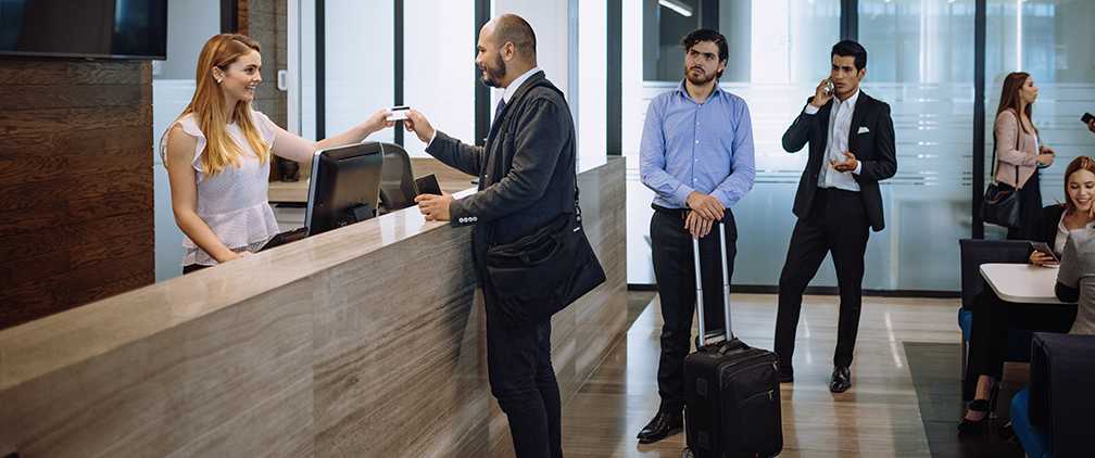 Business travelers checking in luxury hotel Business travelers using credit card at hotel reception