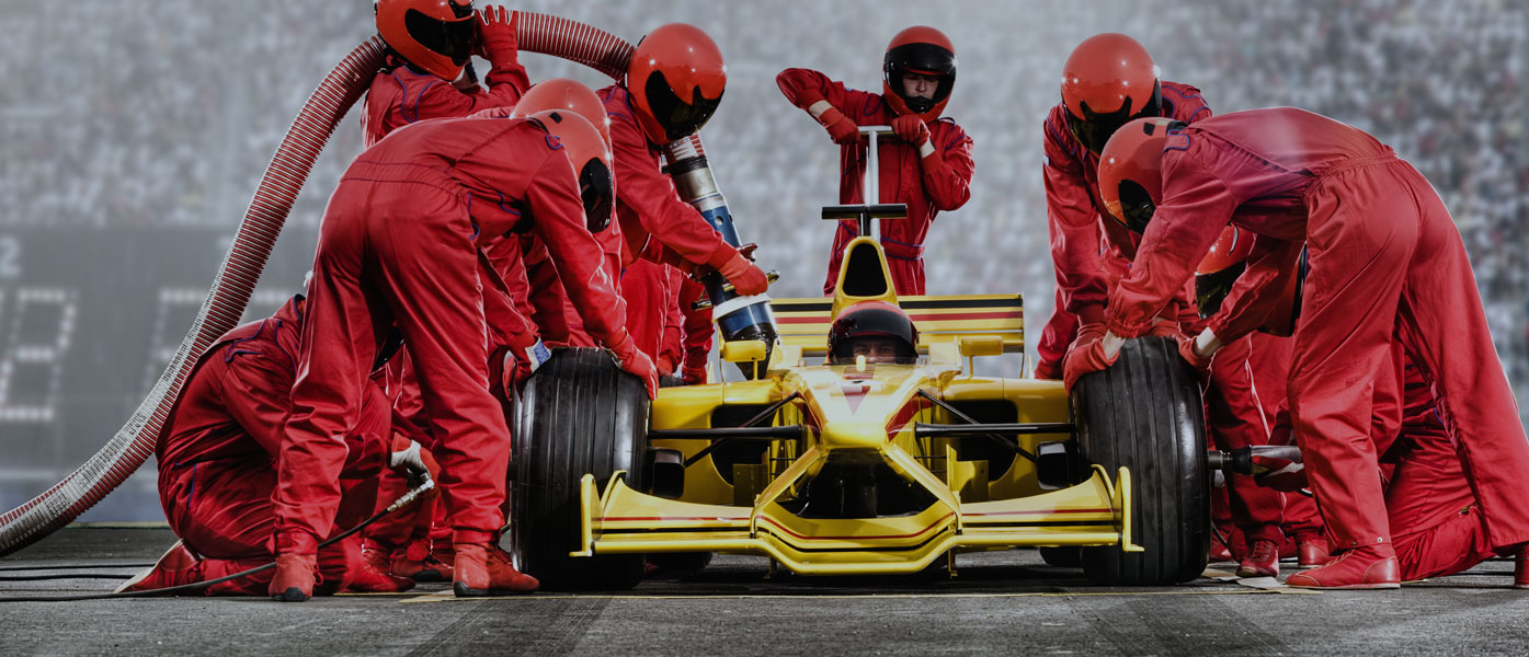 formula 1 car surrounded by pit crew